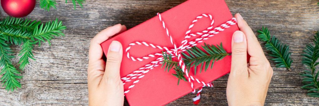 Feature image for Manitoba Gifts in Whiteshell shows a person's hands holding a wrapped gift.