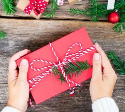 Feature image for Manitoba Gifts in Whiteshell shows a person's hands holding a wrapped gift.