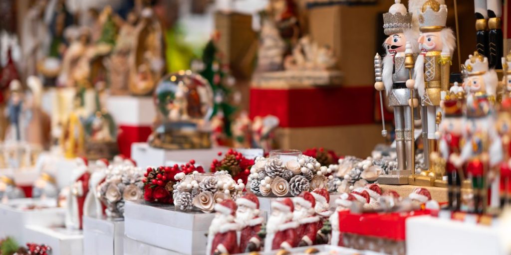 Image shows a table at a holiday market with a variety of Christmas decorations and items.